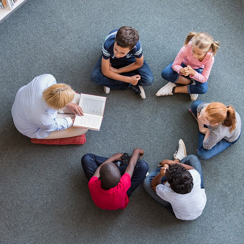 Teacher and children reading in a group setting